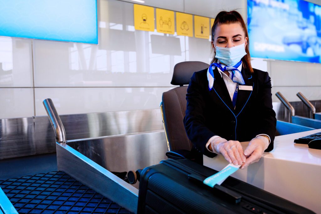 airport ground staff sits counter weighing luggage registration1